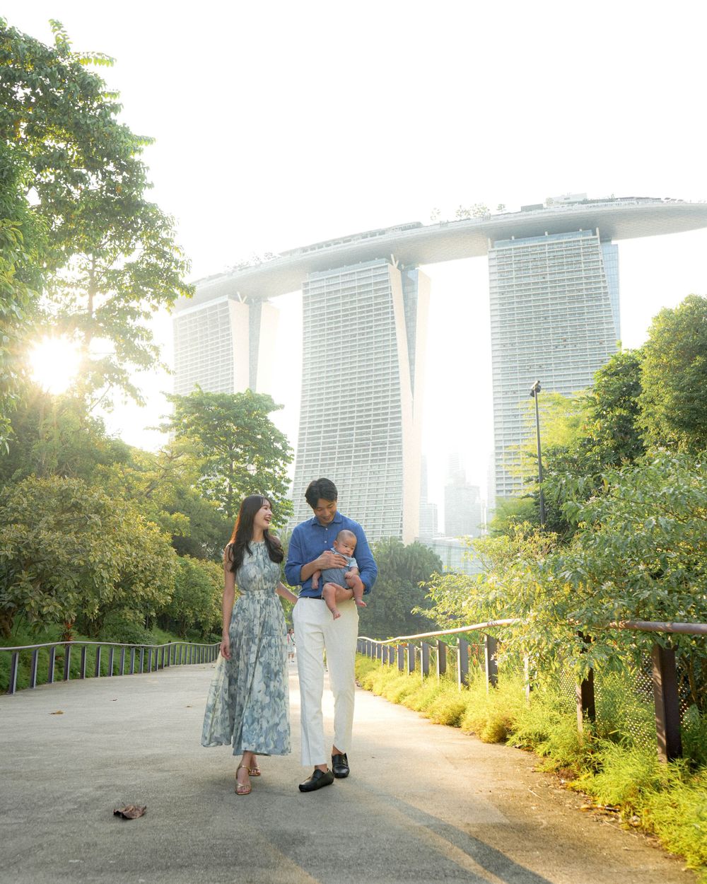 Family walking along Gardens by the Bay path with Marina Bay Sands in view.