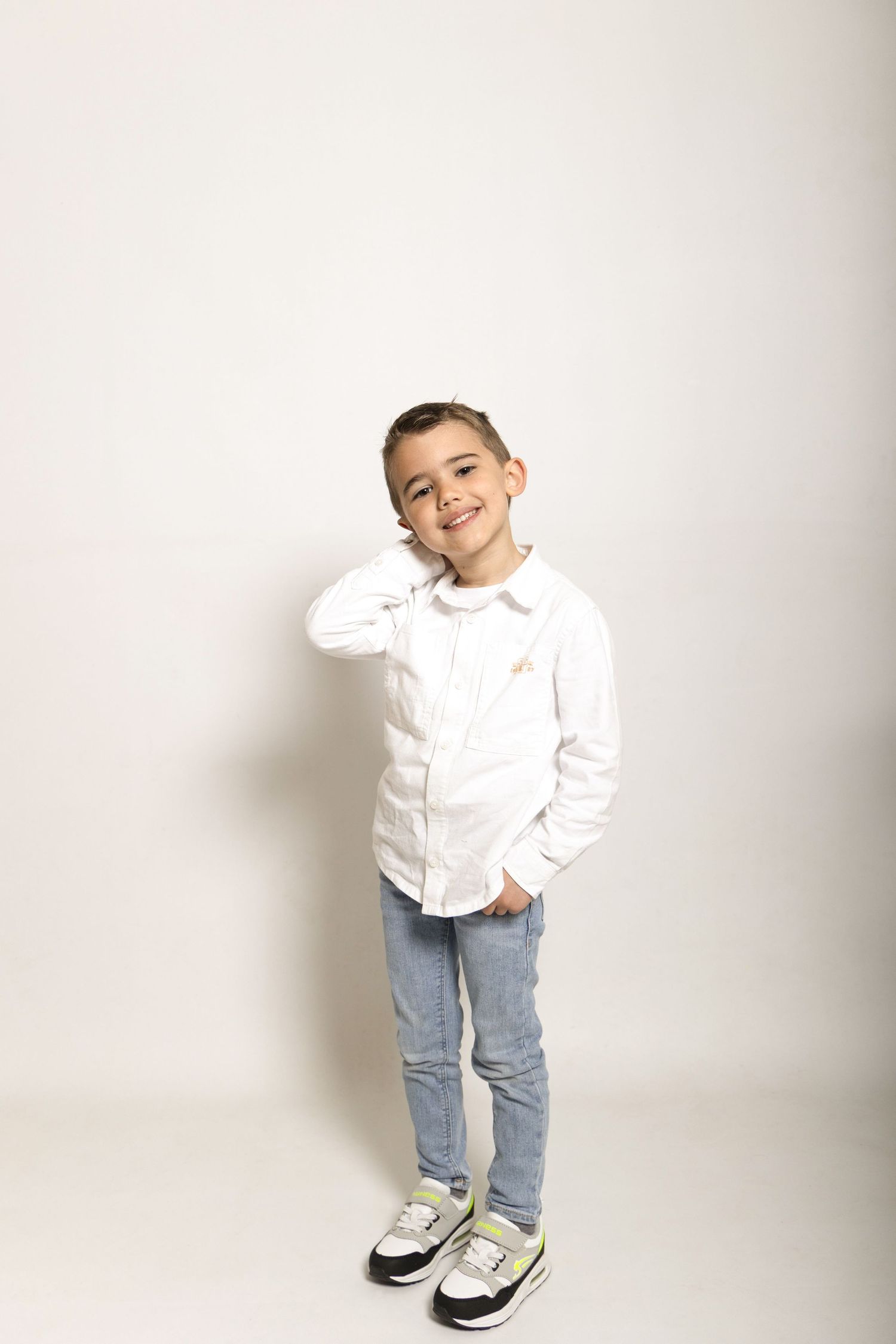 Séance photo d'un petit garçon sur fond blanc en studio