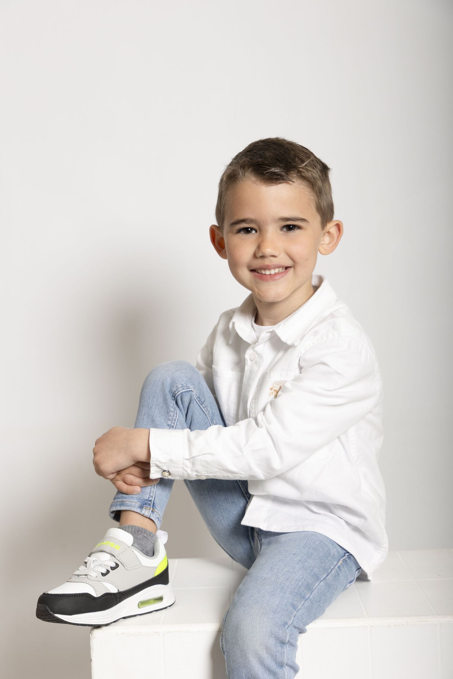 Séance photo d'un petit garçon sur fond blanc en studio
