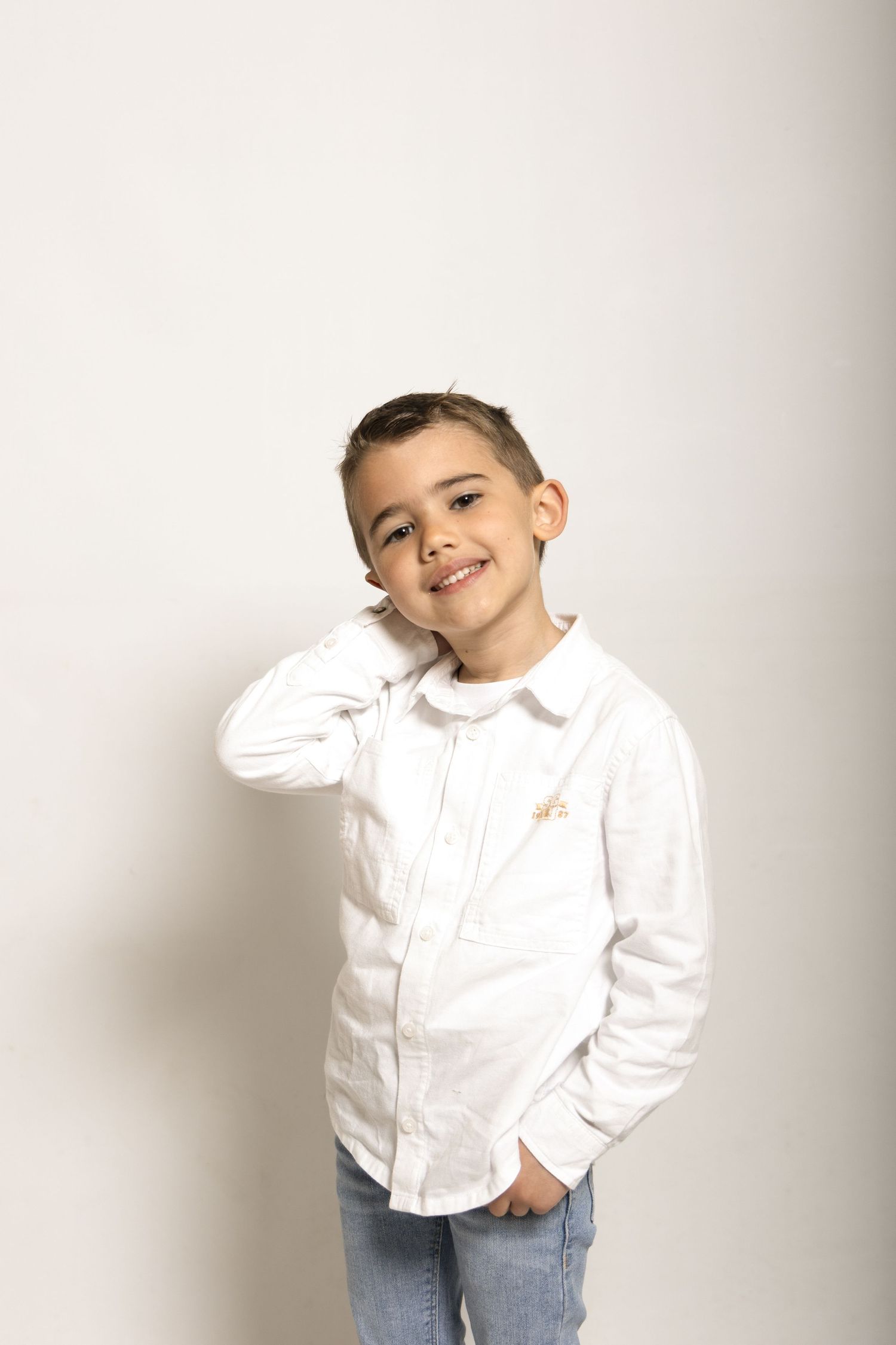 Séance photo d'un petit garçon sur fond blanc en studio