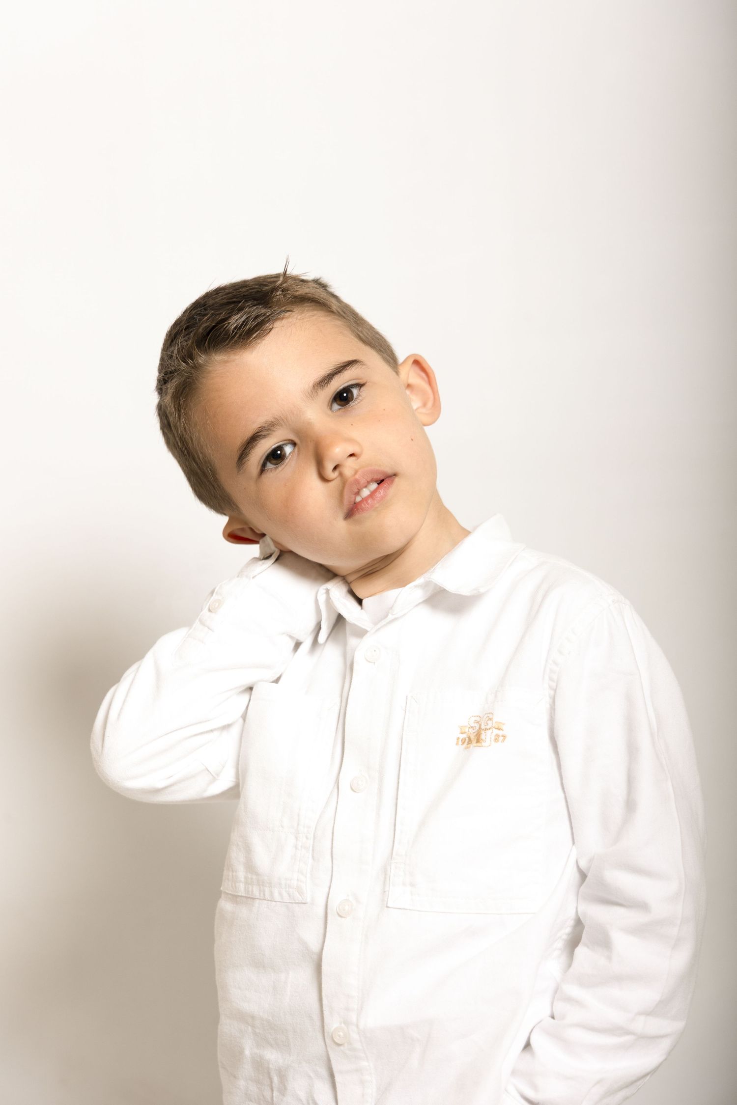Séance photo d'un petit garçon sur fond blanc en studio