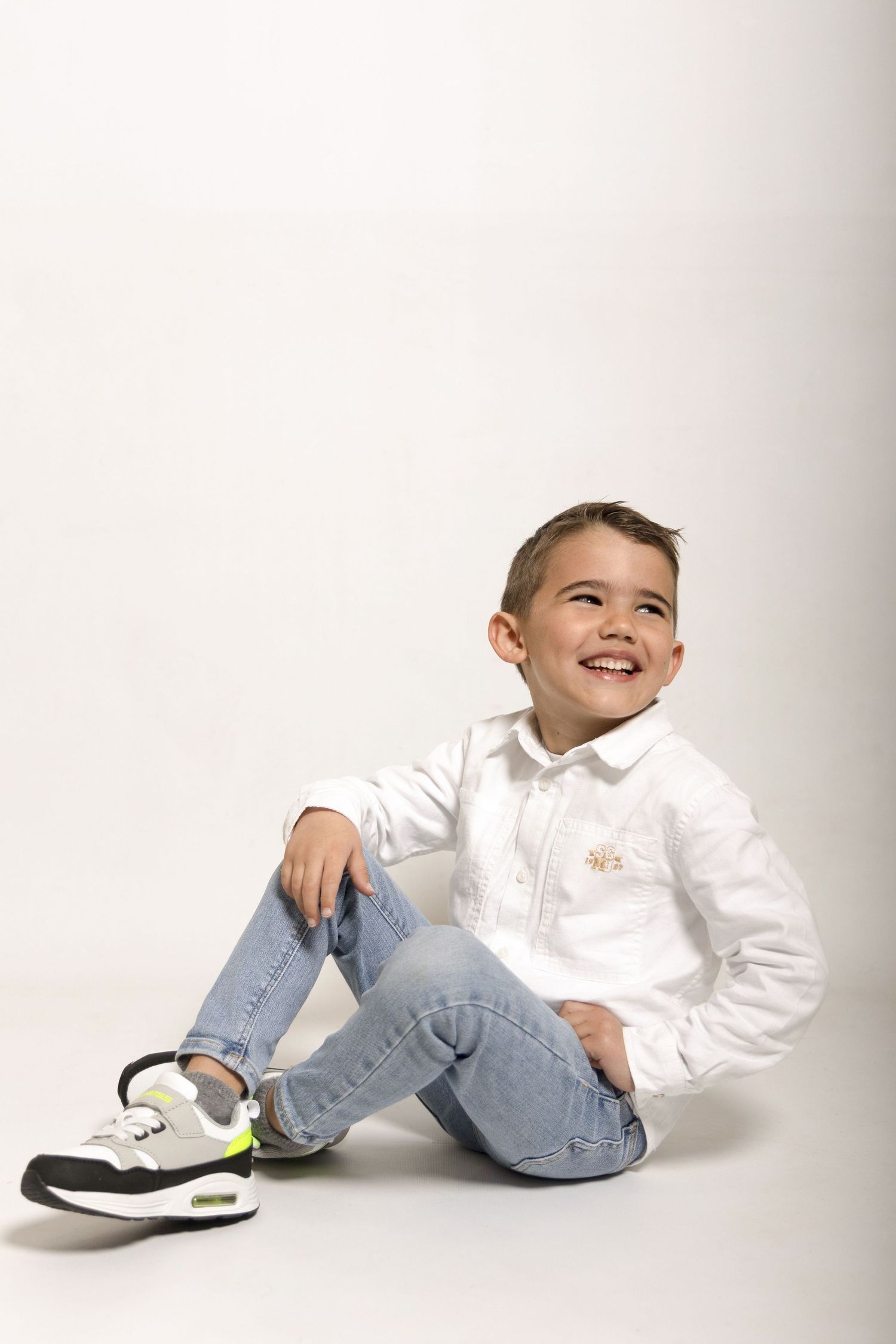 Séance photo d'un petit garçon sur fond blanc en studio