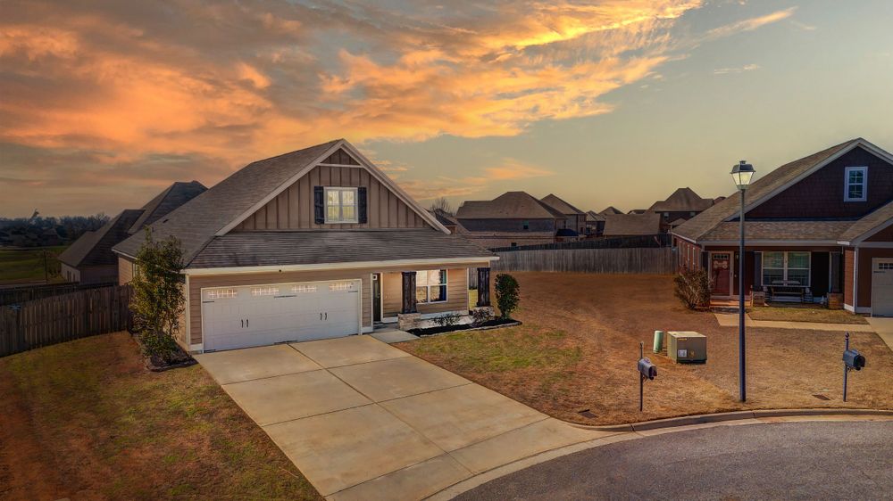 Modern suburban home with two-car garage captured during a vibrant orange sunset.