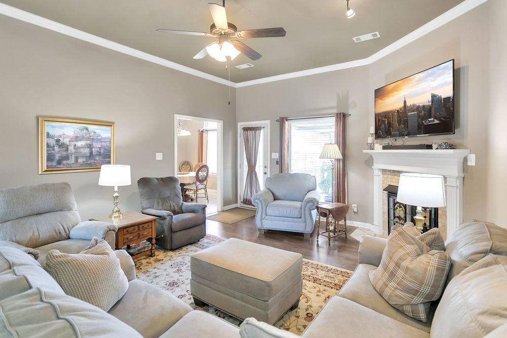 Contemporary living room with fireplace, mounted TV, and comfortable seating arrangement on patterned rug.