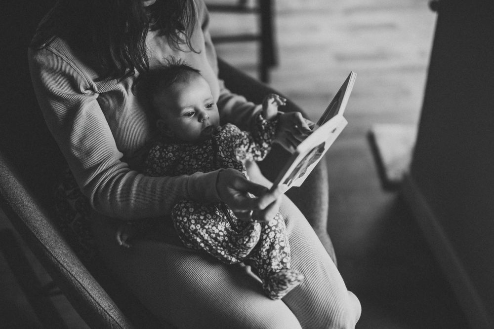 Reading time together in black and white, sharing a quiet moment.