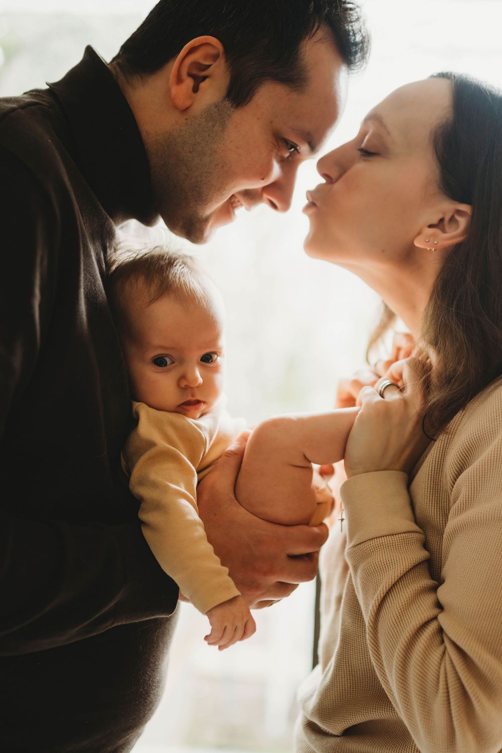 Intimate family portrait bathed in soft natural window light.