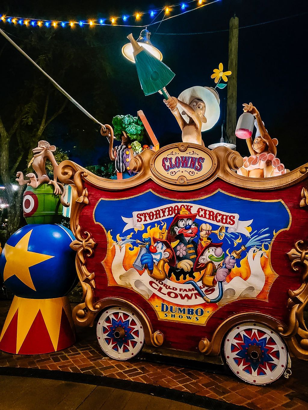 Colorful vintage circus wagon display with Dumbo decorations and string lights at Storybook Circus in Disney World.