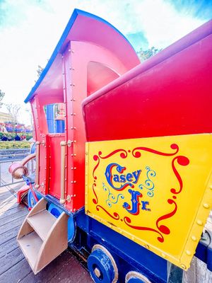 Colorful vintage train car with Casey Jr circus theme in bright red, yellow and blue paint at Disneyland theme park.