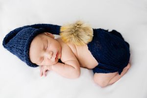 Newborn boy with blue sleepy hat lays posed for his newborn pictures.#NewbornPictures #CarlsbadNM #roswellNM #ArtesiaNM #BabyPictures