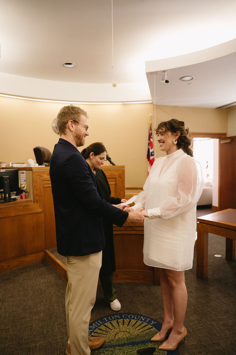 A courthouse wedding ceremony with the couple exchanging vows in front of an officiant.