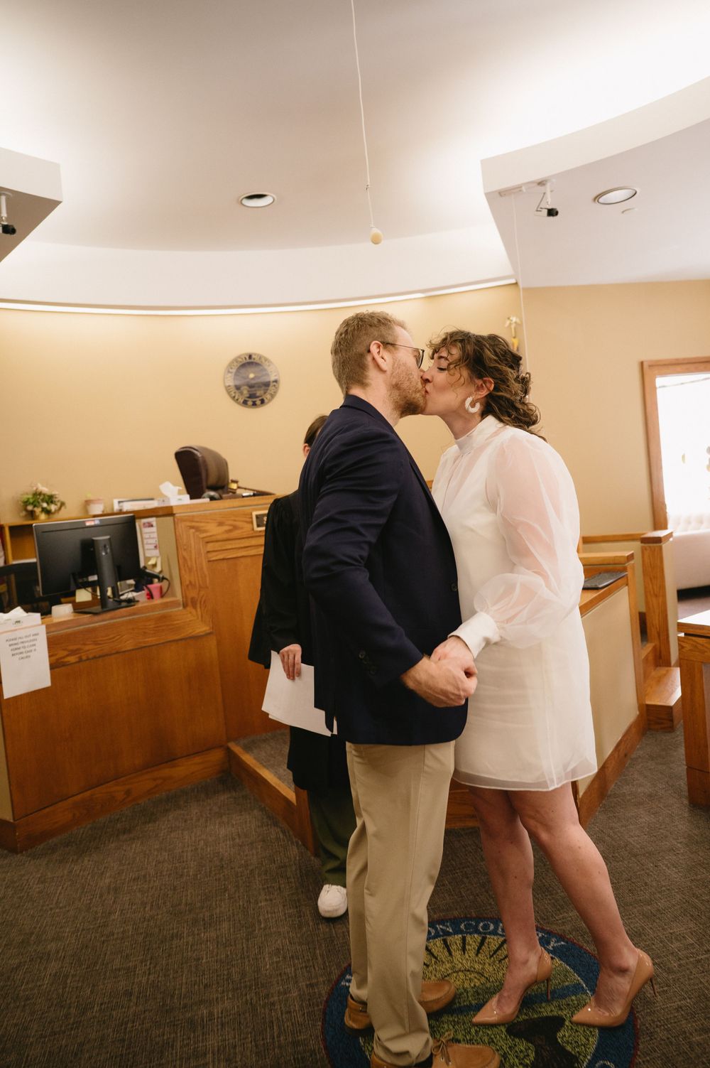 A celebratory kiss at the courthouse after completing the wedding ceremony.