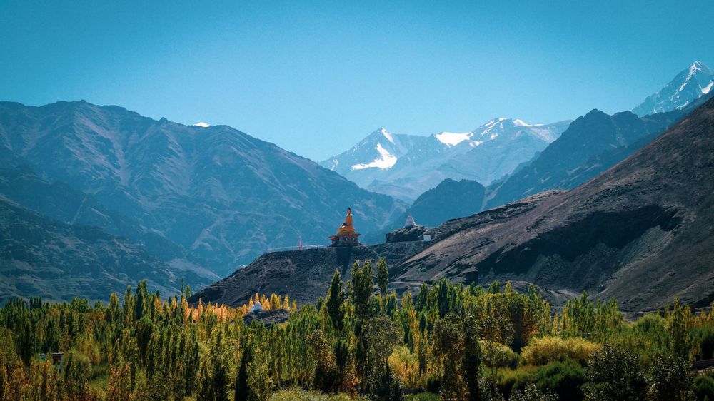 Majestic mountain range with snow-capped peaks under clear blue sky.