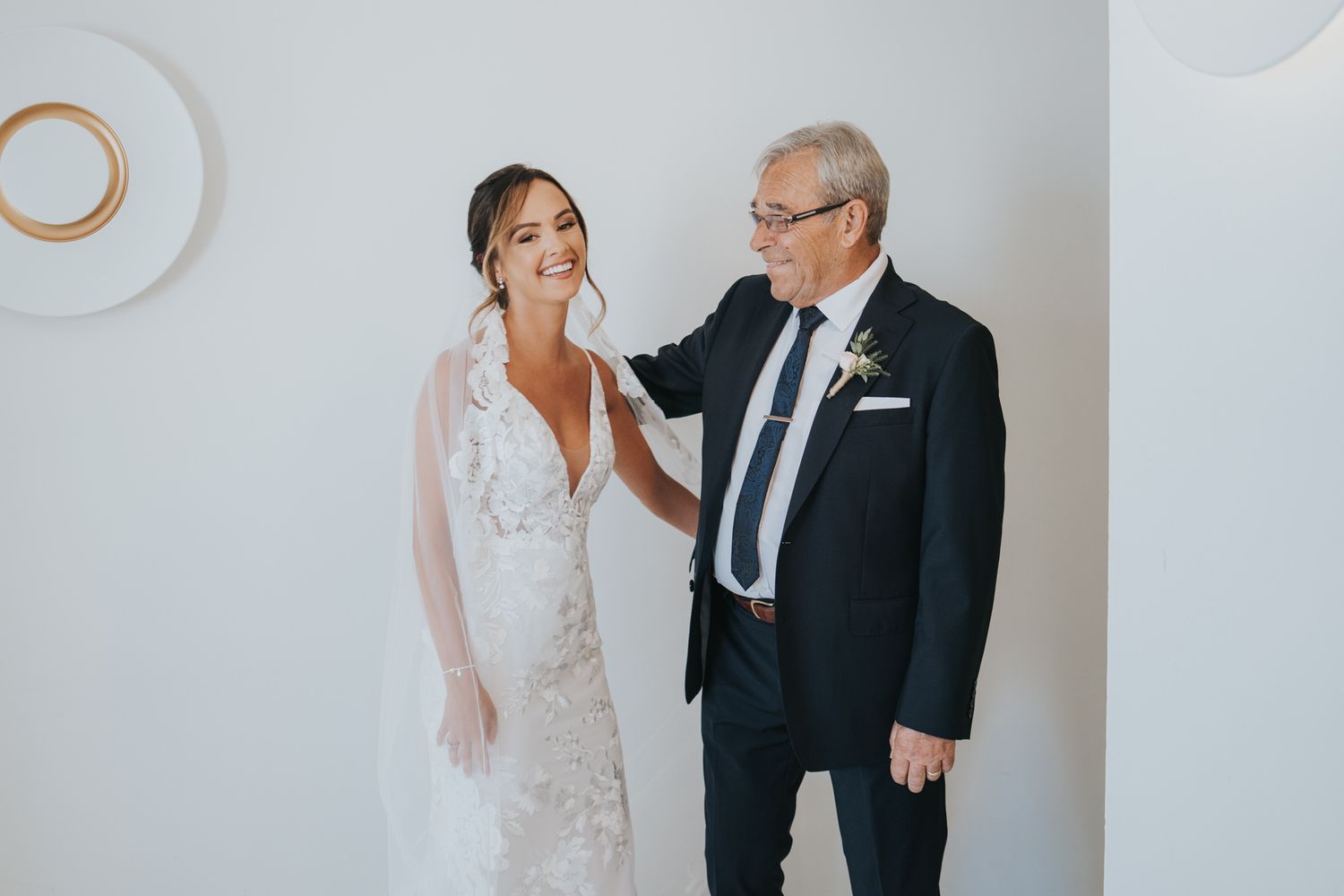 Emotional pre-wedding moment captured in a minimalist white room.