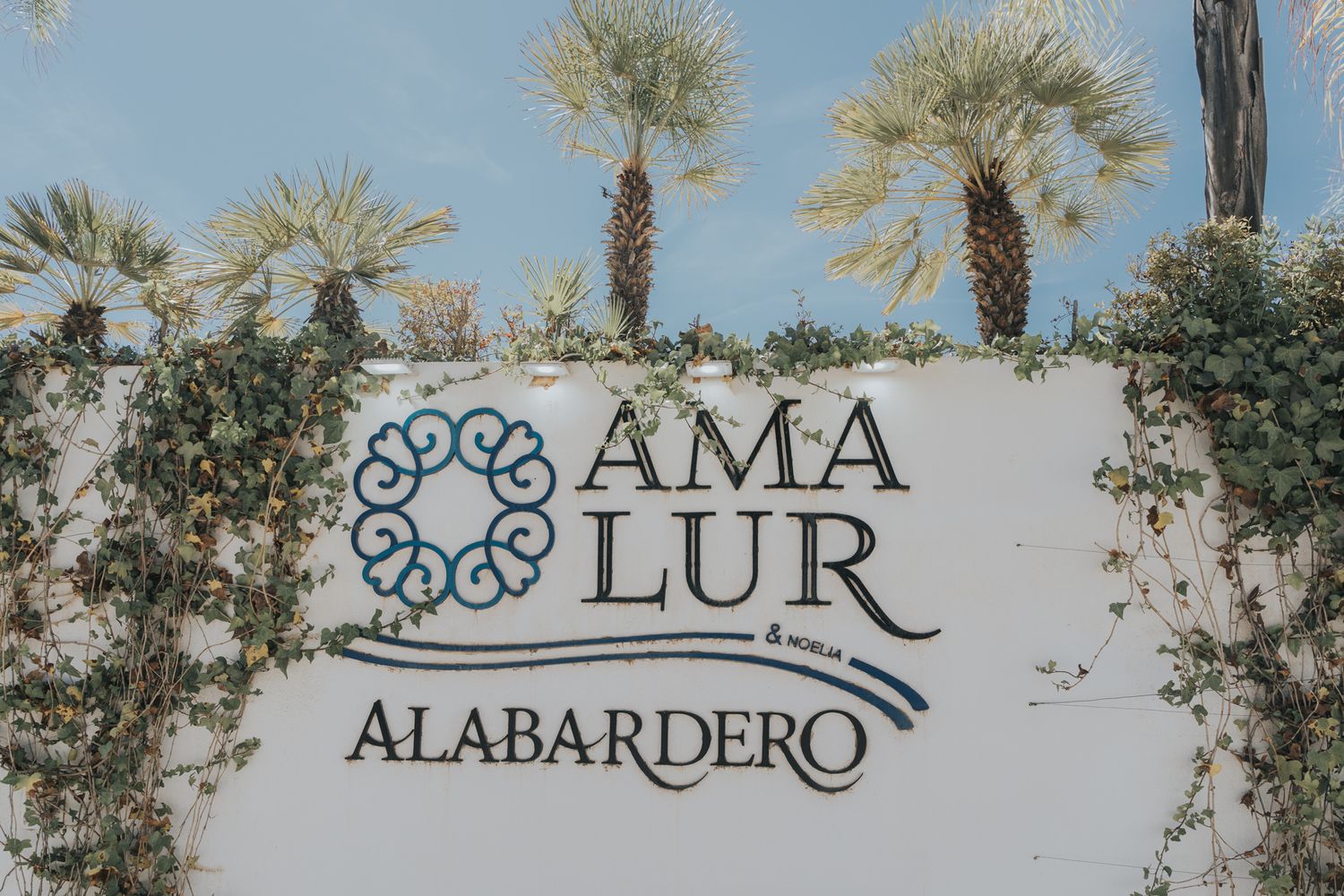 Amalur Alabardero signage with palm trees in the background at an outdoor venue.