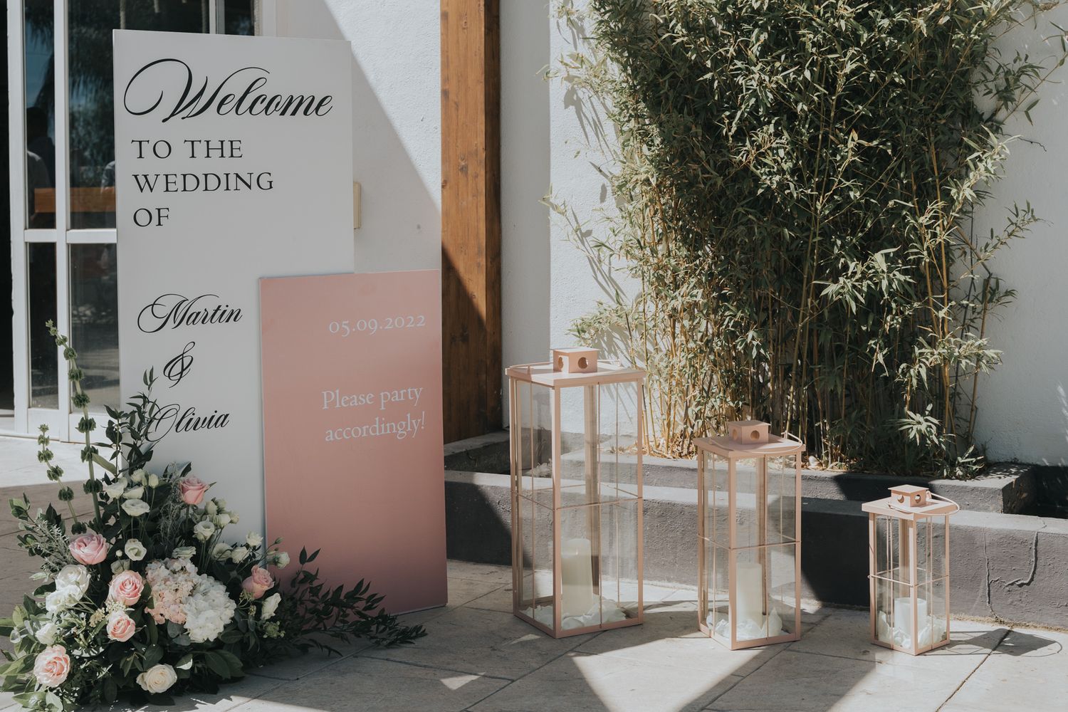 Modern wedding welcome sign with blush tones and lantern decor.