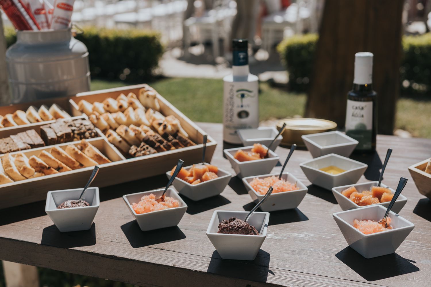 A wedding appetizer station with various dipping sauces and bread displayed on a rustic table.