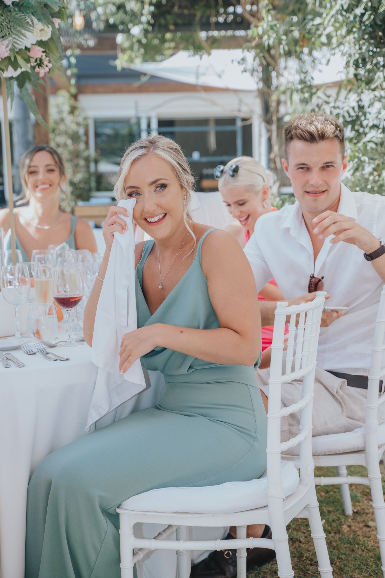 Wedding guests enjoying drinks and conversation at an elegant outdoor table setting.