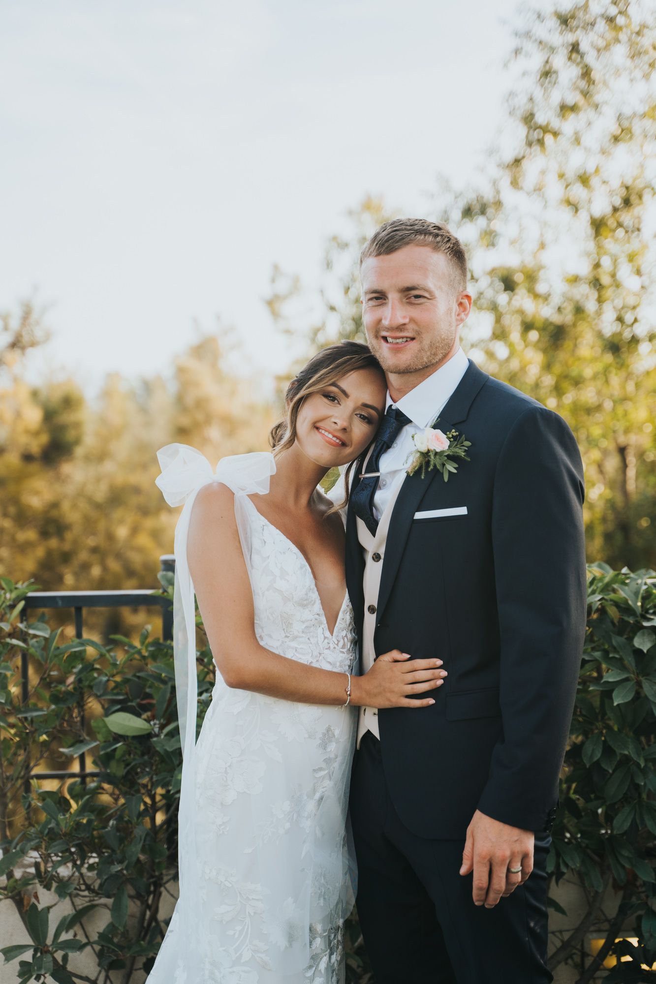 Intimate wedding portrait against autumn foliage backdrop.