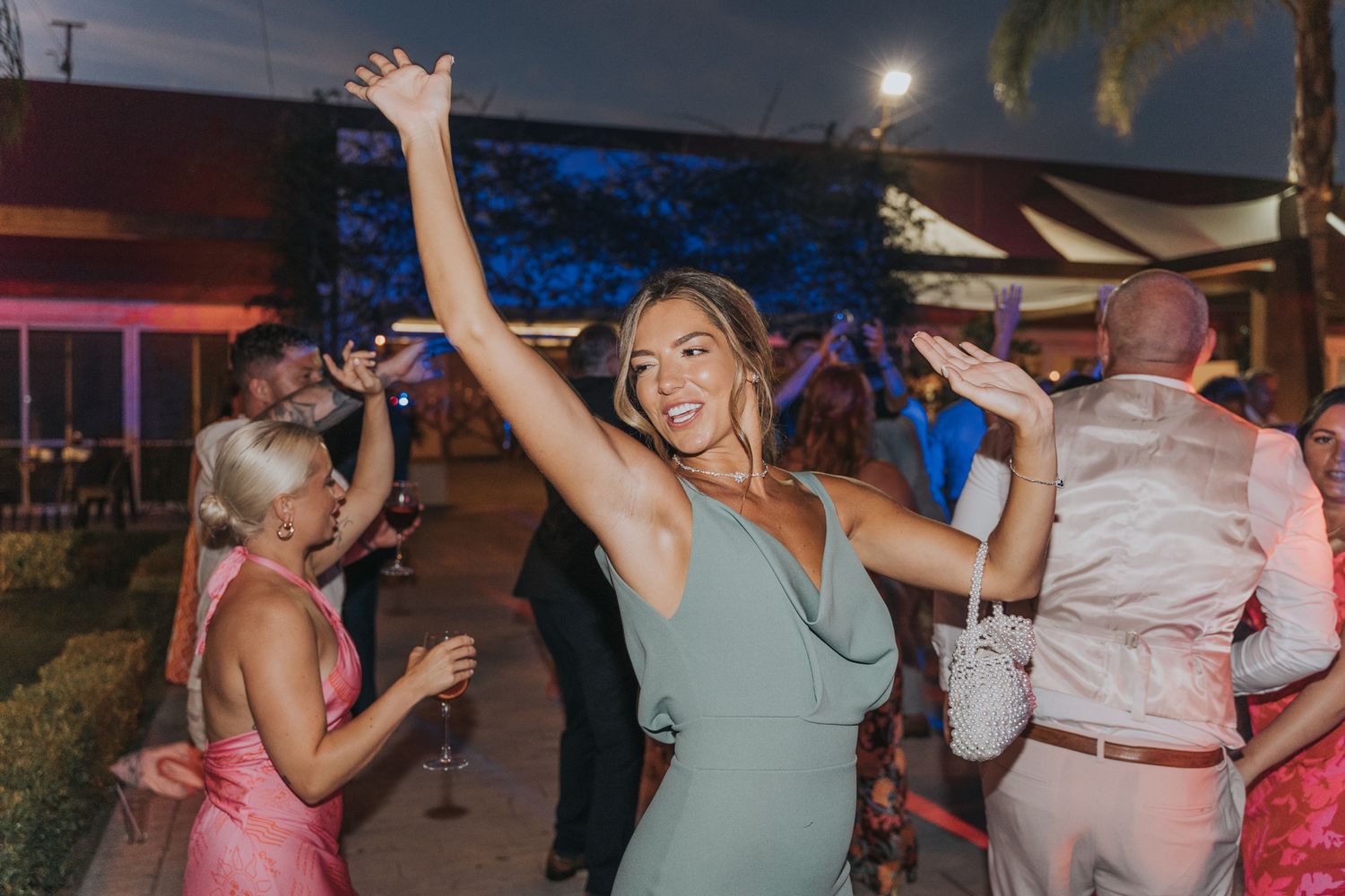 Guests dancing and celebrating at a lively outdoor evening wedding reception.