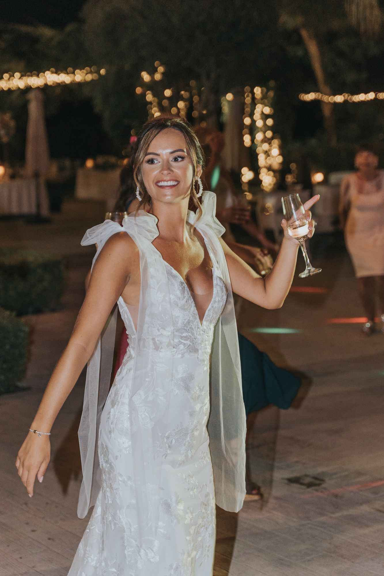 A celebratory moment at a wedding reception with twinkling lights in the background.