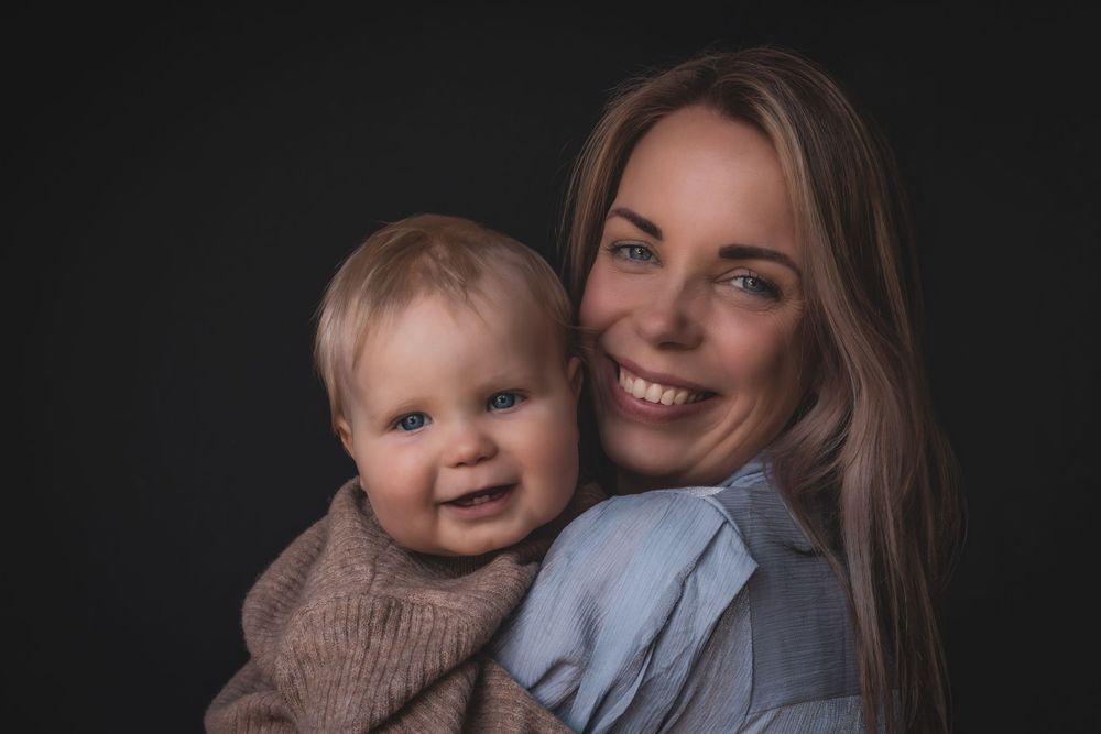 An intimate portrait against dark background showing joyful expressions and warm connection.