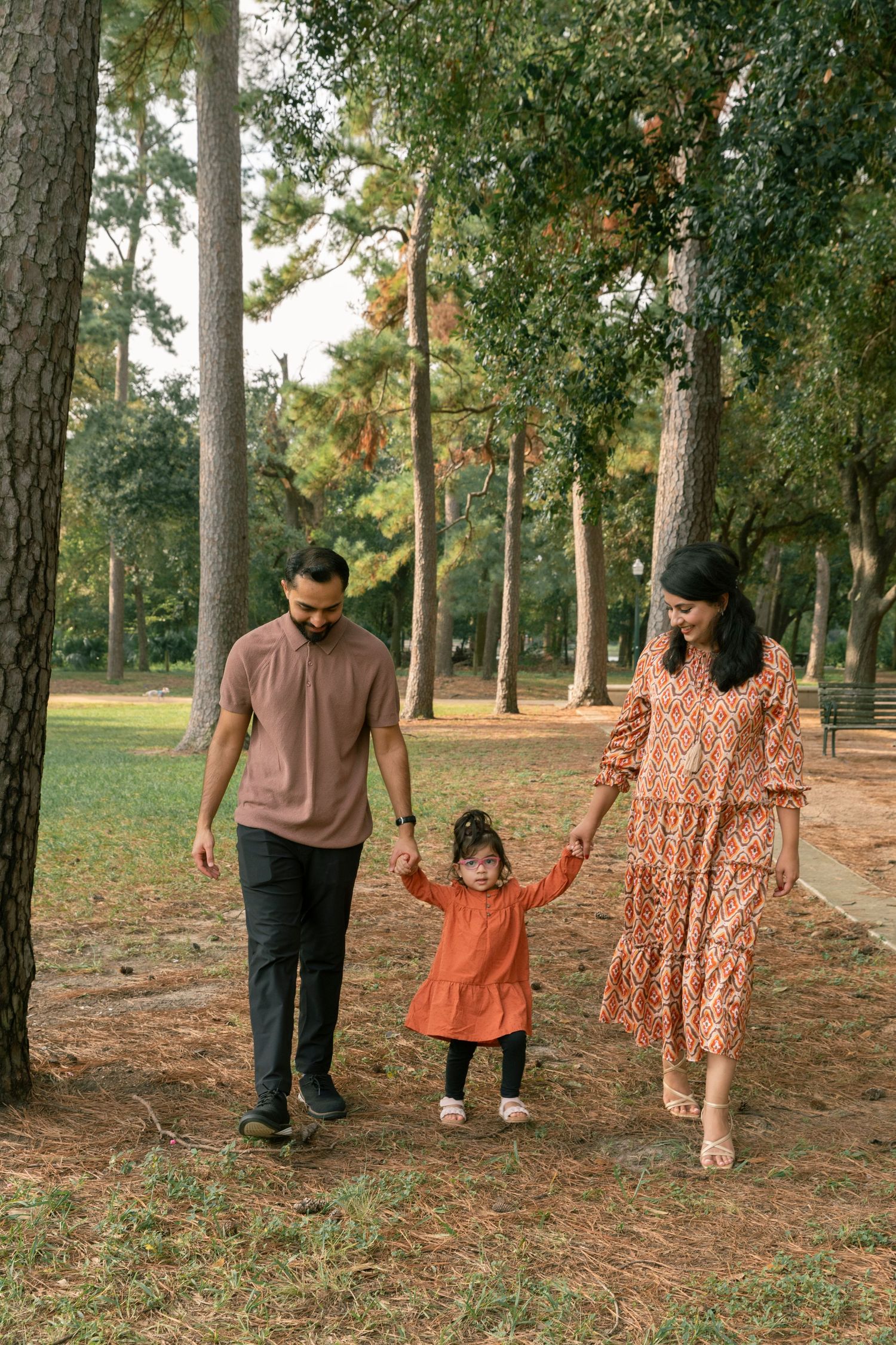 Two people embrace and dance joyfully in an outdoor setting with trees in the background.