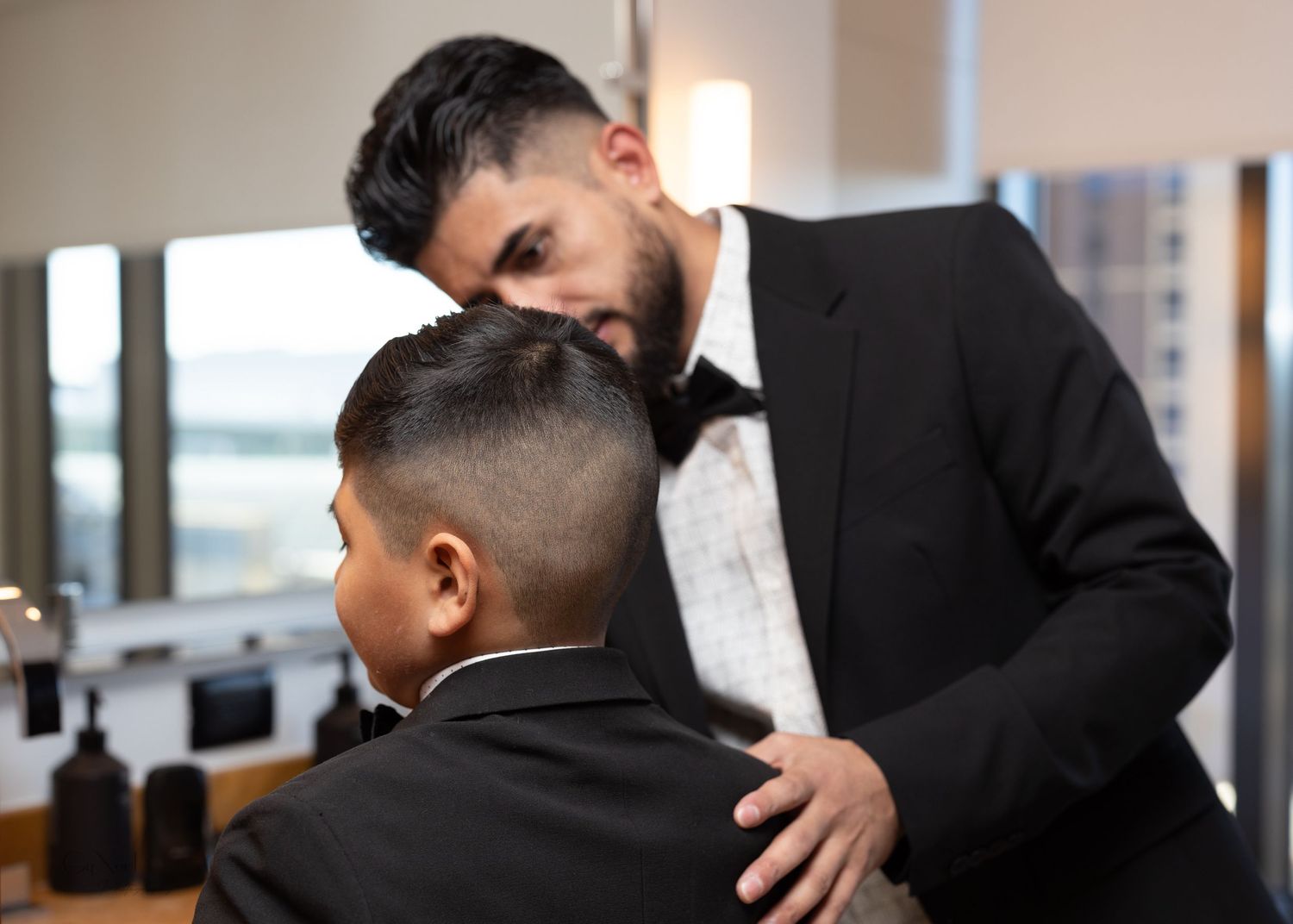 Wedding day preparation scene with formal attire adjustments.