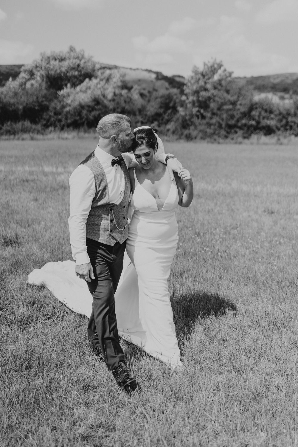 Bride and groom walking together intimate natural photo in the field