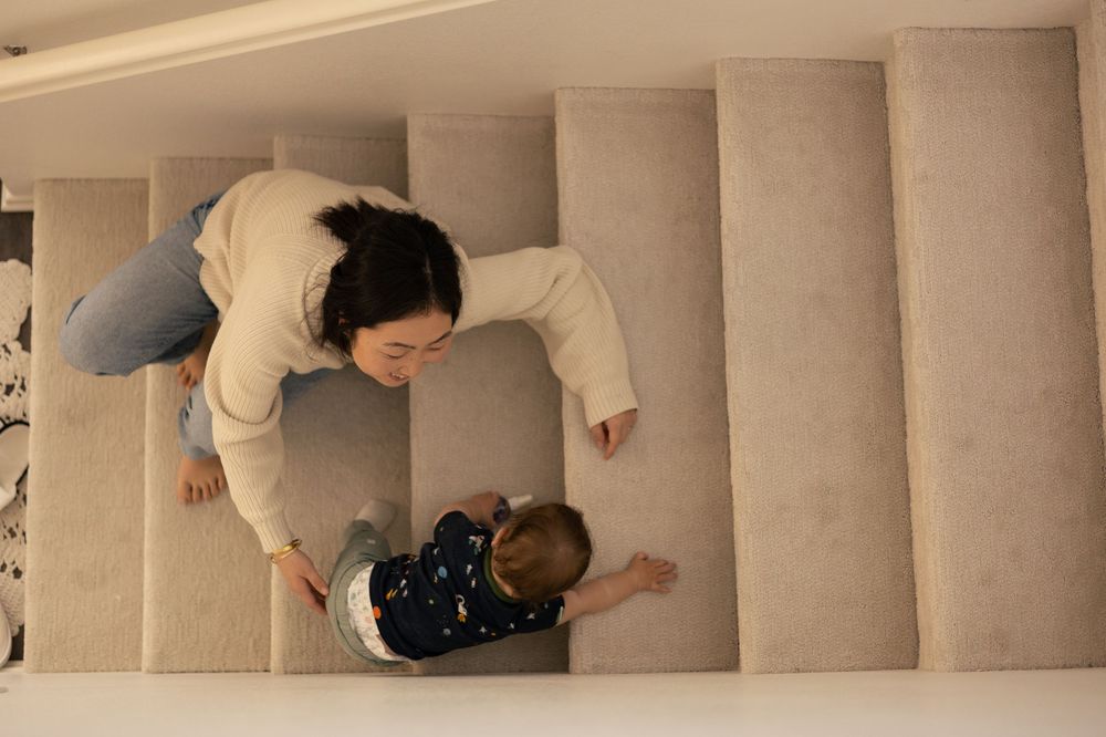 Overhead shot of mom and toddler boy playing in the stairs at a cozy, in-home session in Murrieta, CA.
