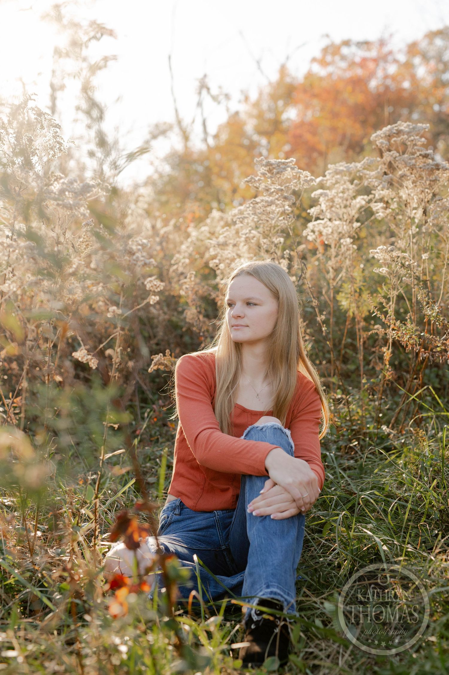 Sunset portrait in a meadow with dried wildflowers and warm autumn lighting.