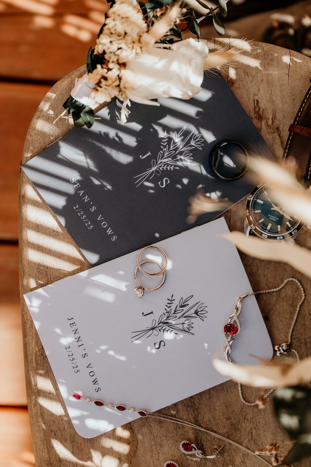 Elegant wedding stationery with floral designs cast in dramatic shadows.
