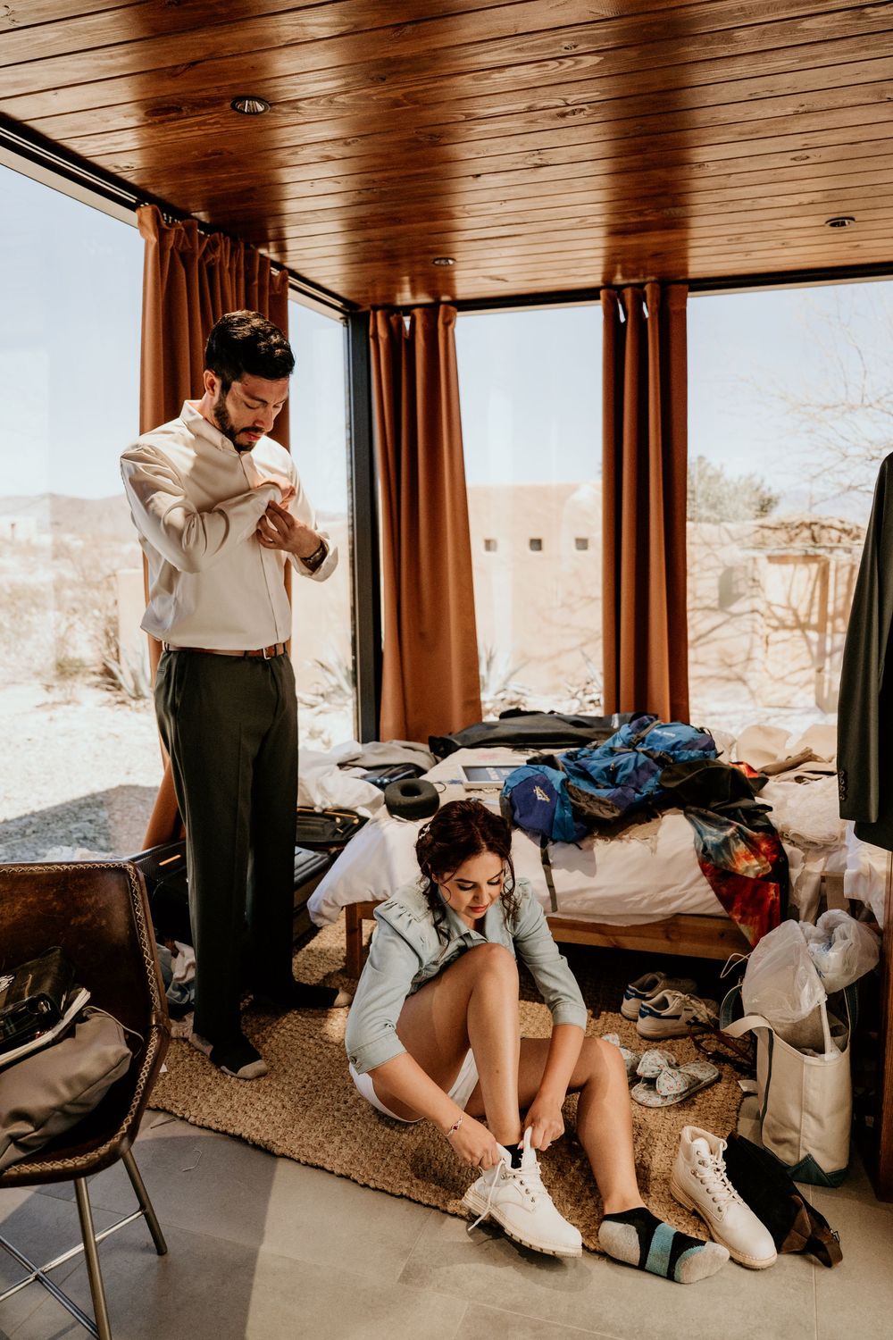 Getting ready scene in a wood-paneled room with desert views through the windows.