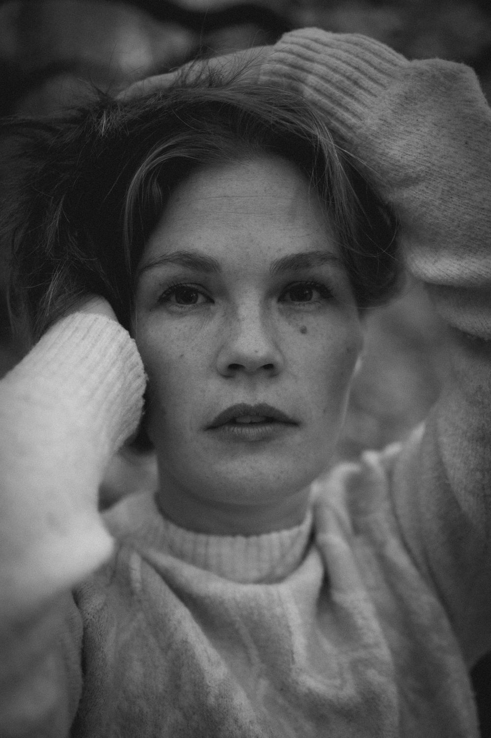 A black and white artistic portrait series showing different facial expressions and poses in a soft focus style.