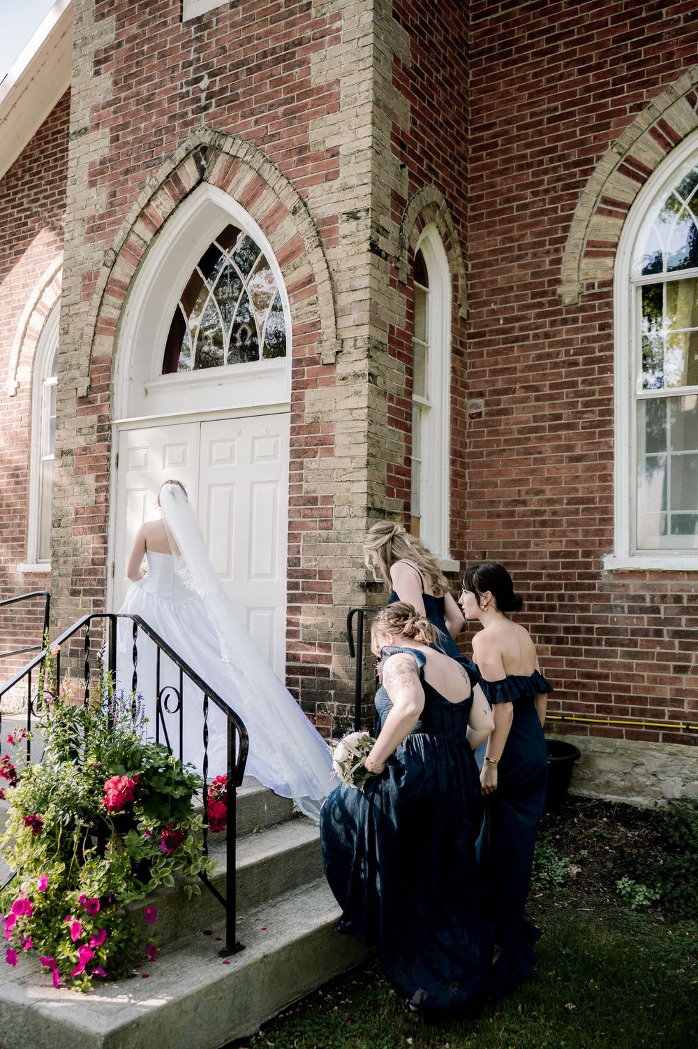 A series of photos showing a bride and bridesmaid sharing a sweet moment outside a brick church with white doors.