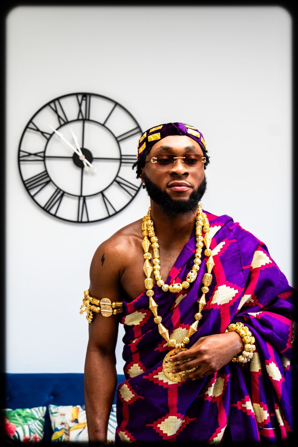 A series of photos showing someone in vibrant purple traditional African attire with gold jewelry against a white background.