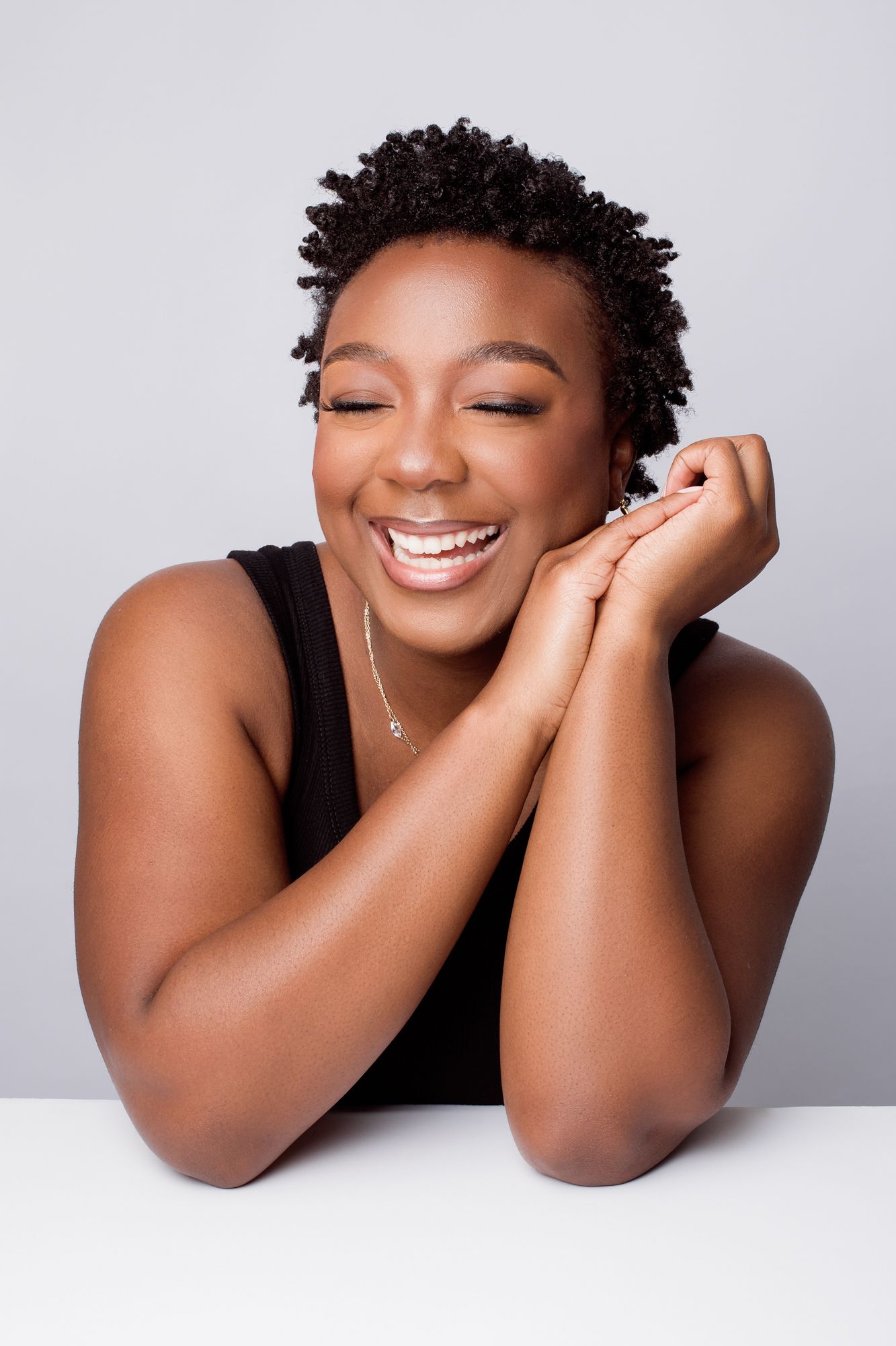 A series of joyful portrait shots against a white background showing natural curly hair and genuine expressions of happiness.