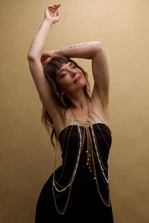 Artistic photo series showing dancer in black top with pearl necklaces moving gracefully against sepia background.