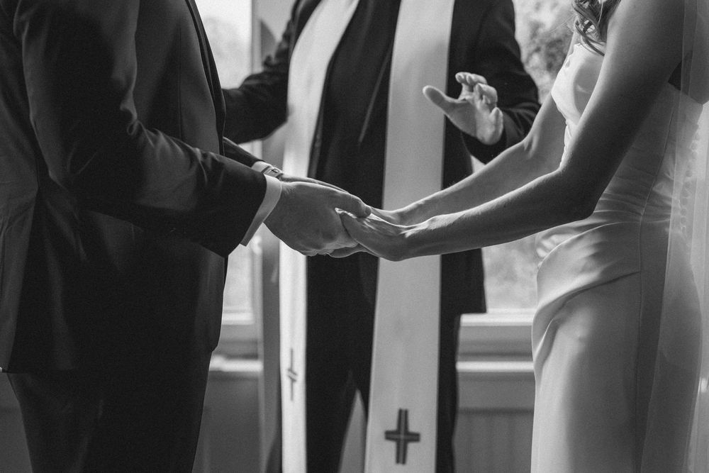 A couple shares an intimate dance moment during their wedding reception in a softly lit venue.