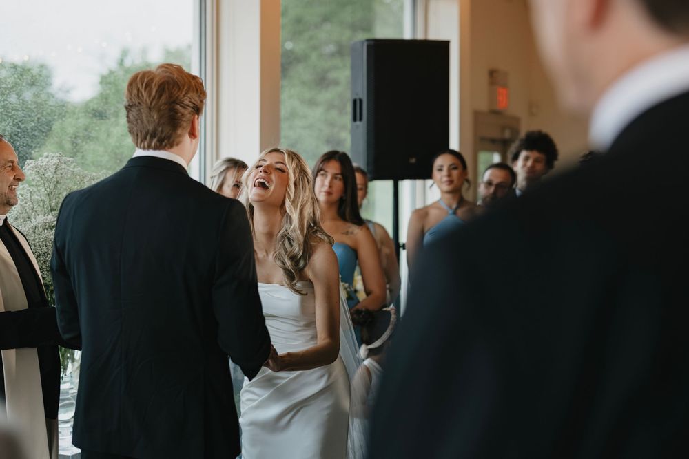 A group of wedding guests mingling and conversing during a reception in an elegant indoor venue.