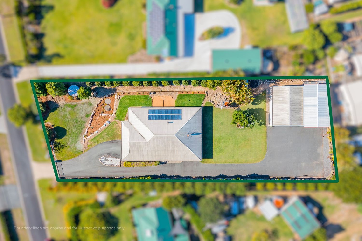 Aerial view of single-story home with solar panels, circular driveway, and well-maintained gardens on a suburban block.