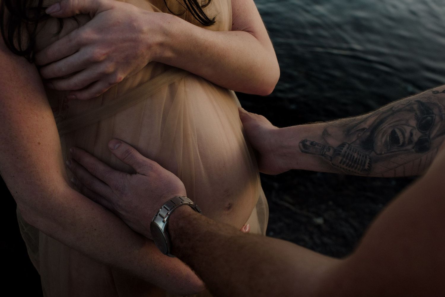 A sequence of intimate close-up shots showing hands gently touching in dark lighting conditions.