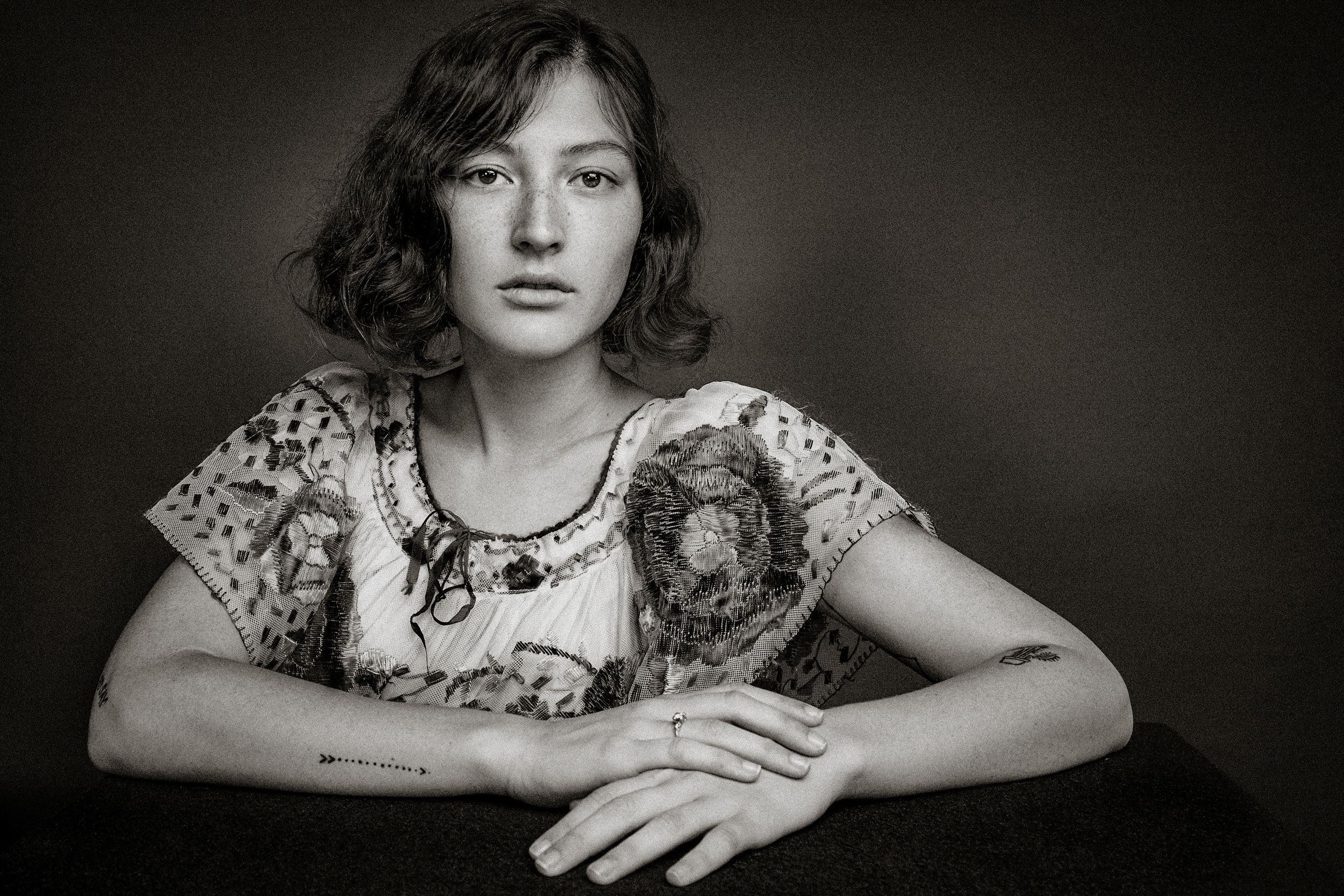 Vintage black and white portrait series showing a person in a floral dress posing in different positions.