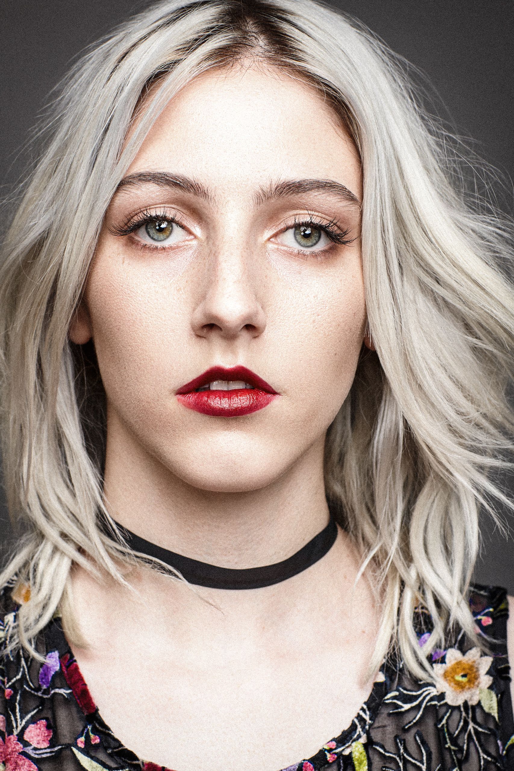 A series of artistic portraits showing platinum blonde hair and red lipstick against a dark background.