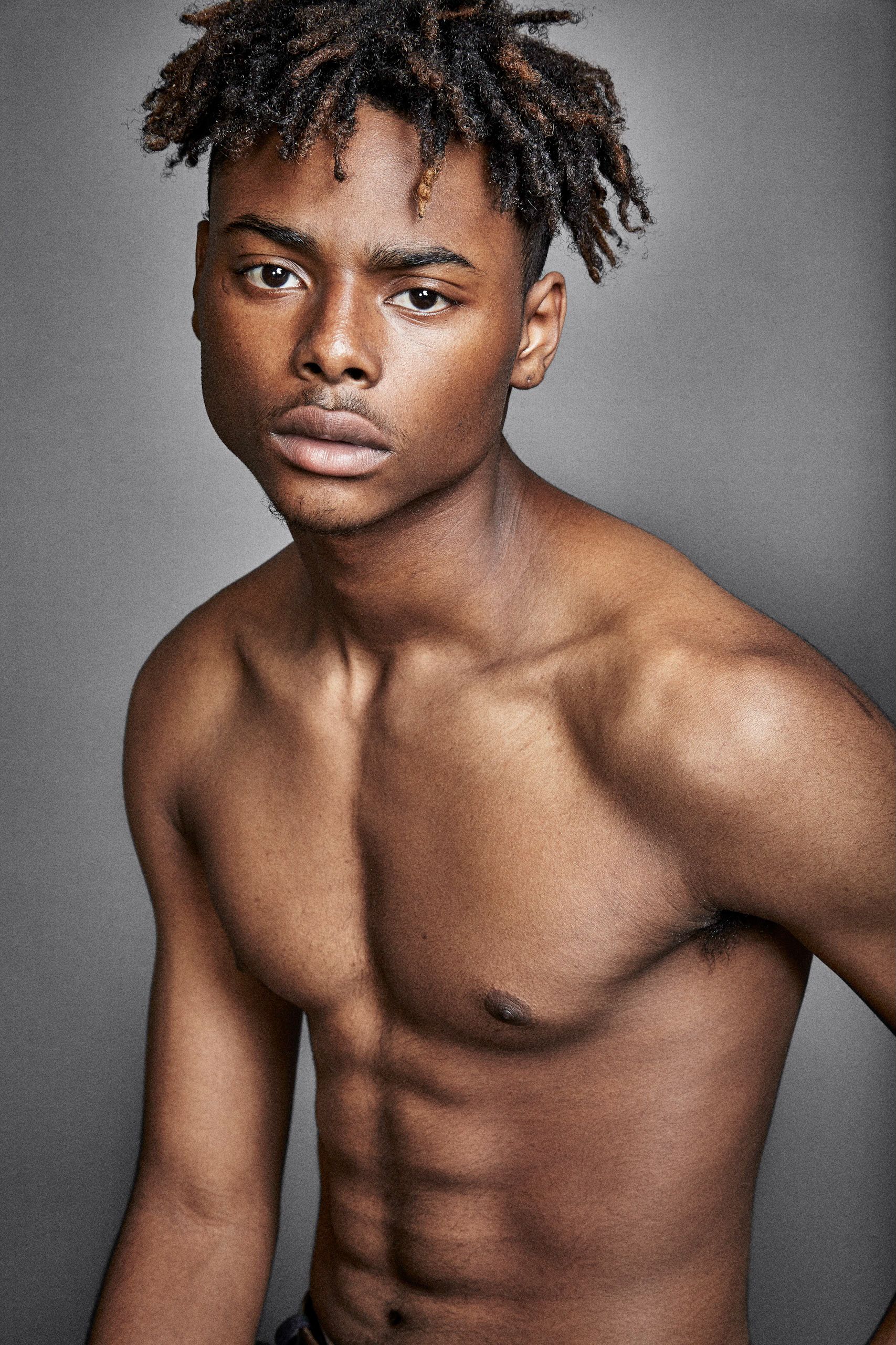 Artistic portrait series showing shirtless athletic figure with natural hair against gray studio backdrop.