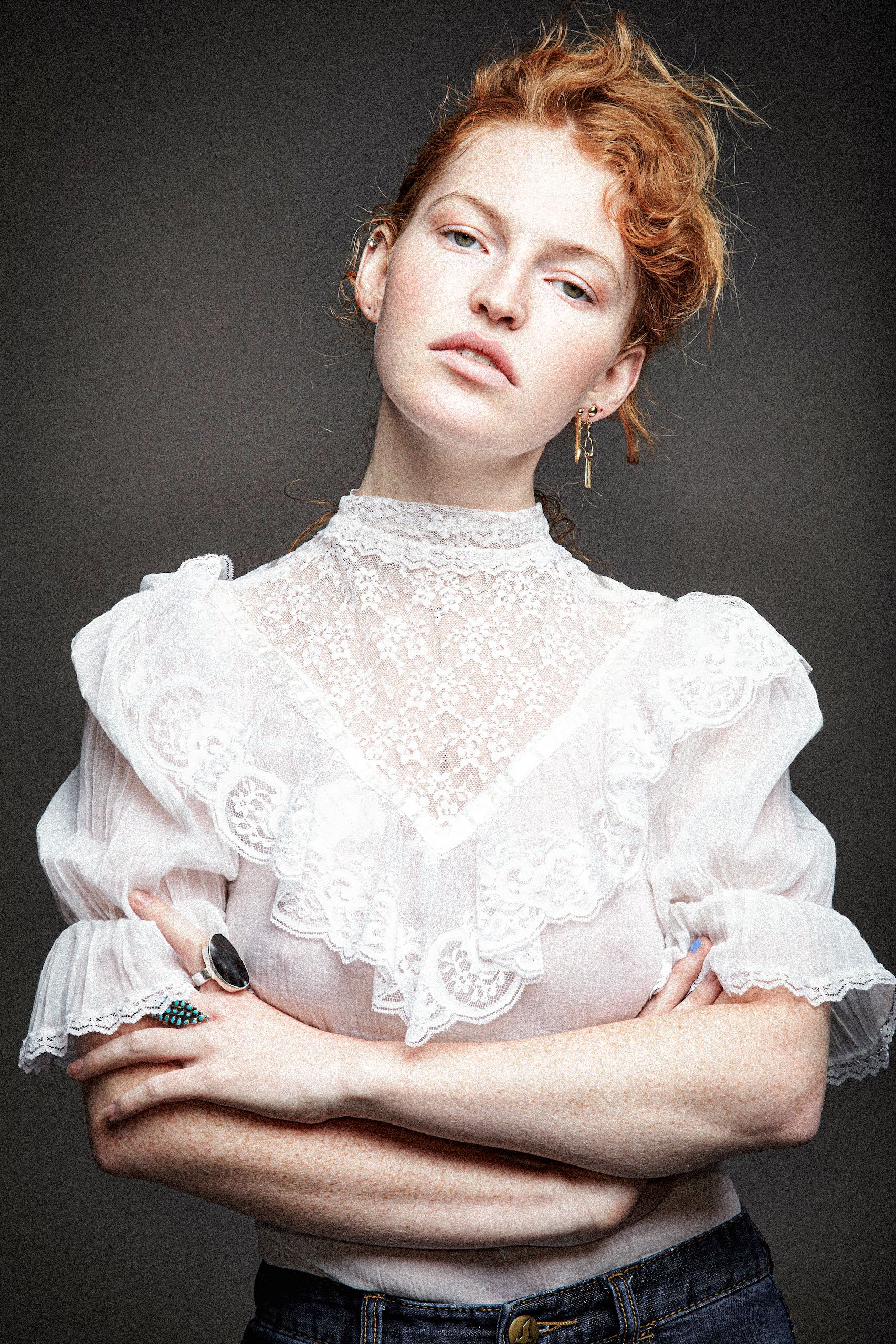A fashion portrait series featuring a model in a Victorian-style white lace blouse against a dark background.