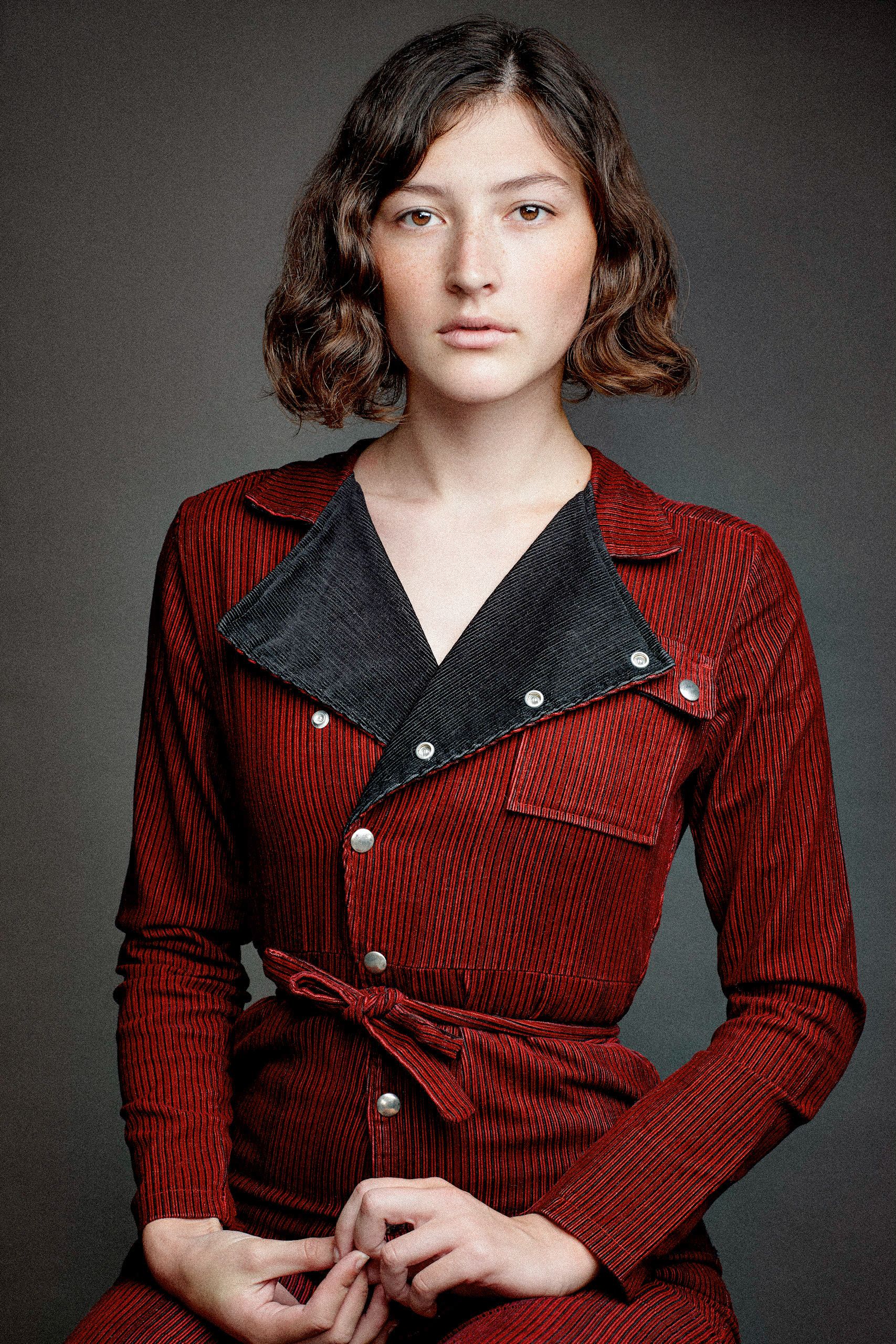 A series of studio portraits showing someone in a red corduroy jacket with black lapels against a dark gray background.