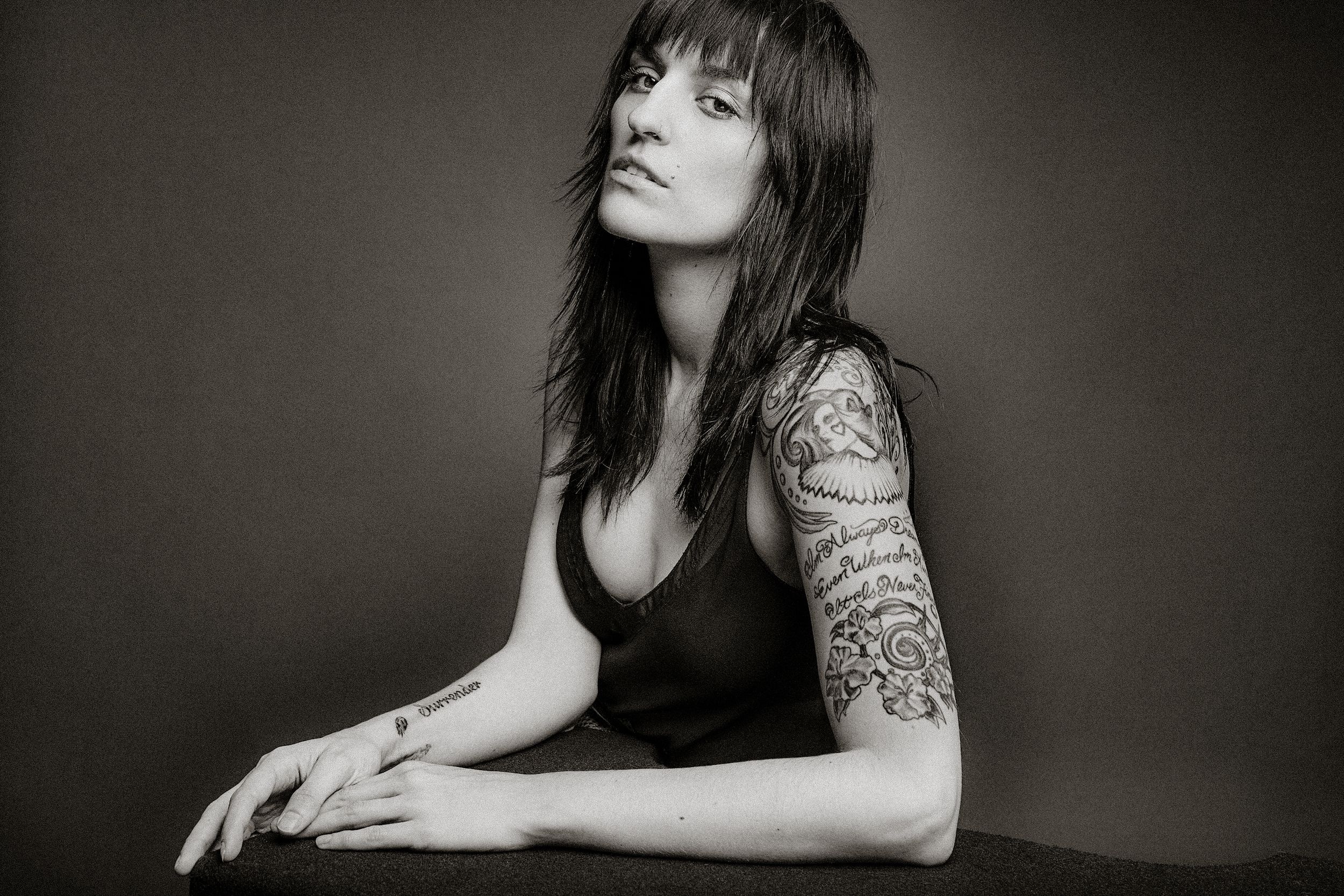 Black and white portrait series showing dramatic shadows and poses of someone wearing lace sleeves against dark background.