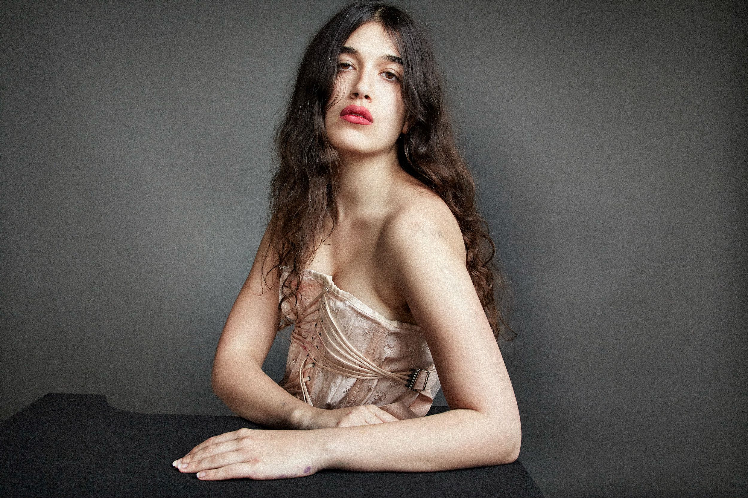 Studio portraits of a woman in elegant poses with dramatic lighting against a dark background.