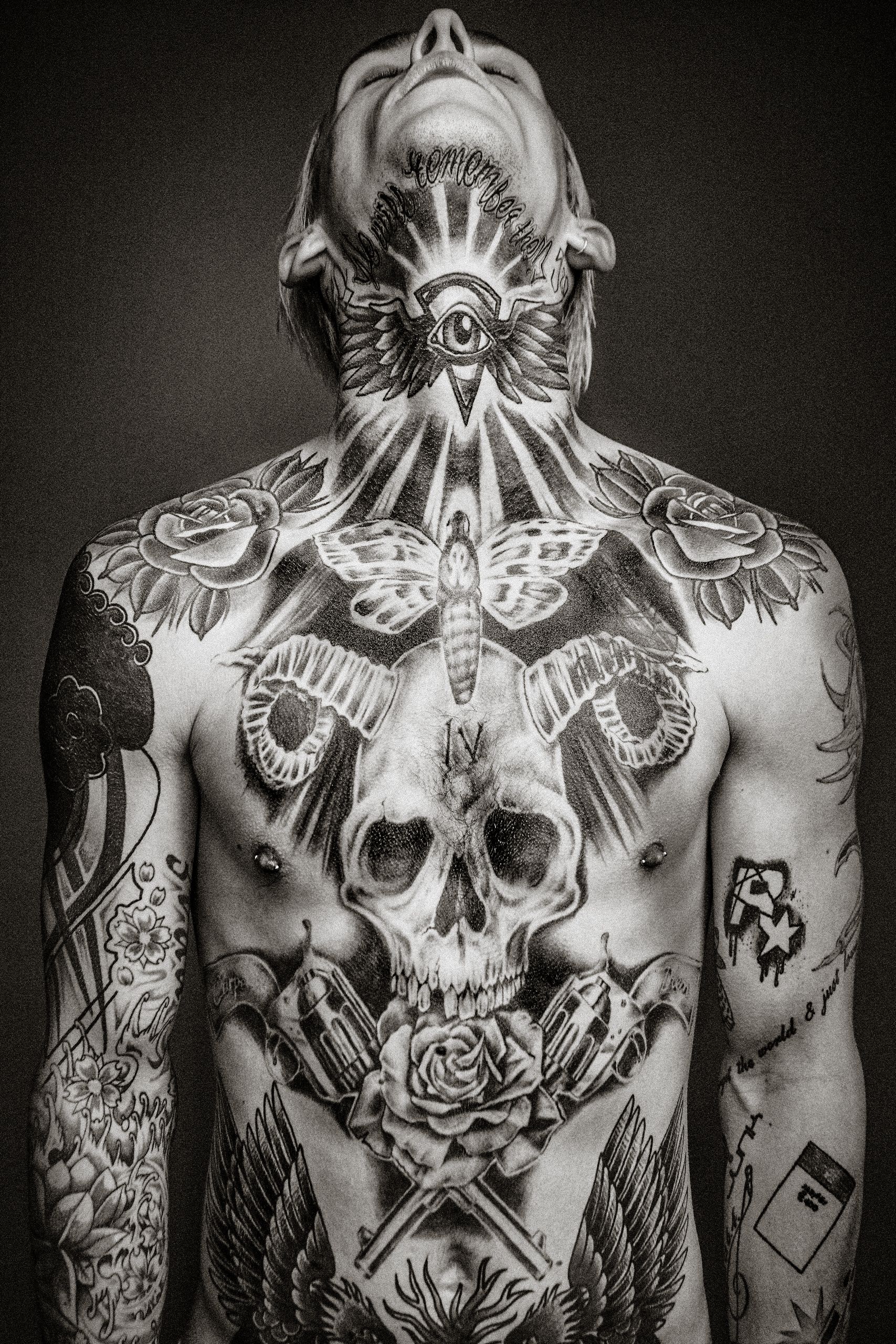 Black and white artistic photographs showing intricate tattoo designs across multiple torsos in a dark moody style.