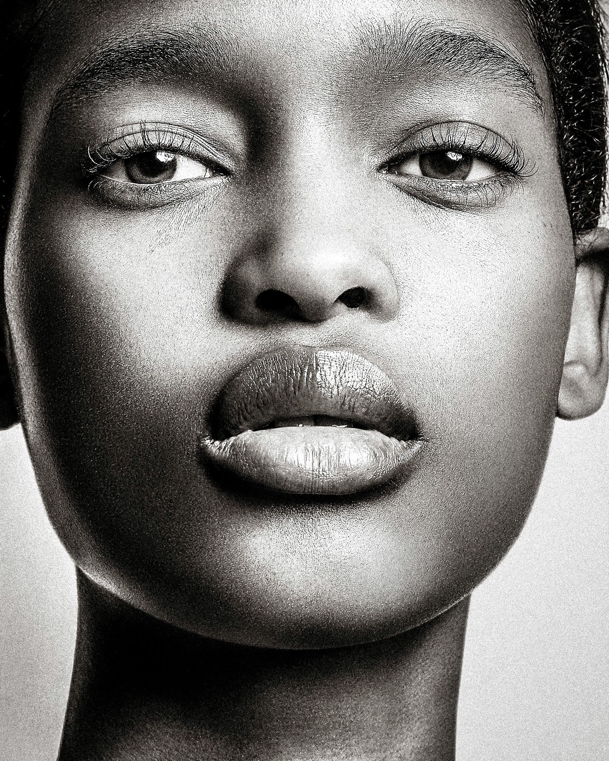 A series of black and white close-up portraits showing expressive facial features in dramatic lighting.